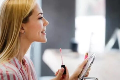 young woman looking herself in a mirror